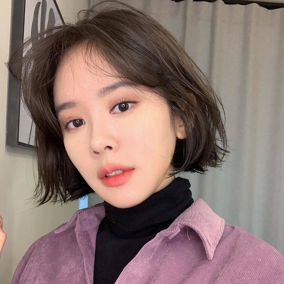 Femme avec des cheveux asiatiques courts et une coupe de cheveux au carré.