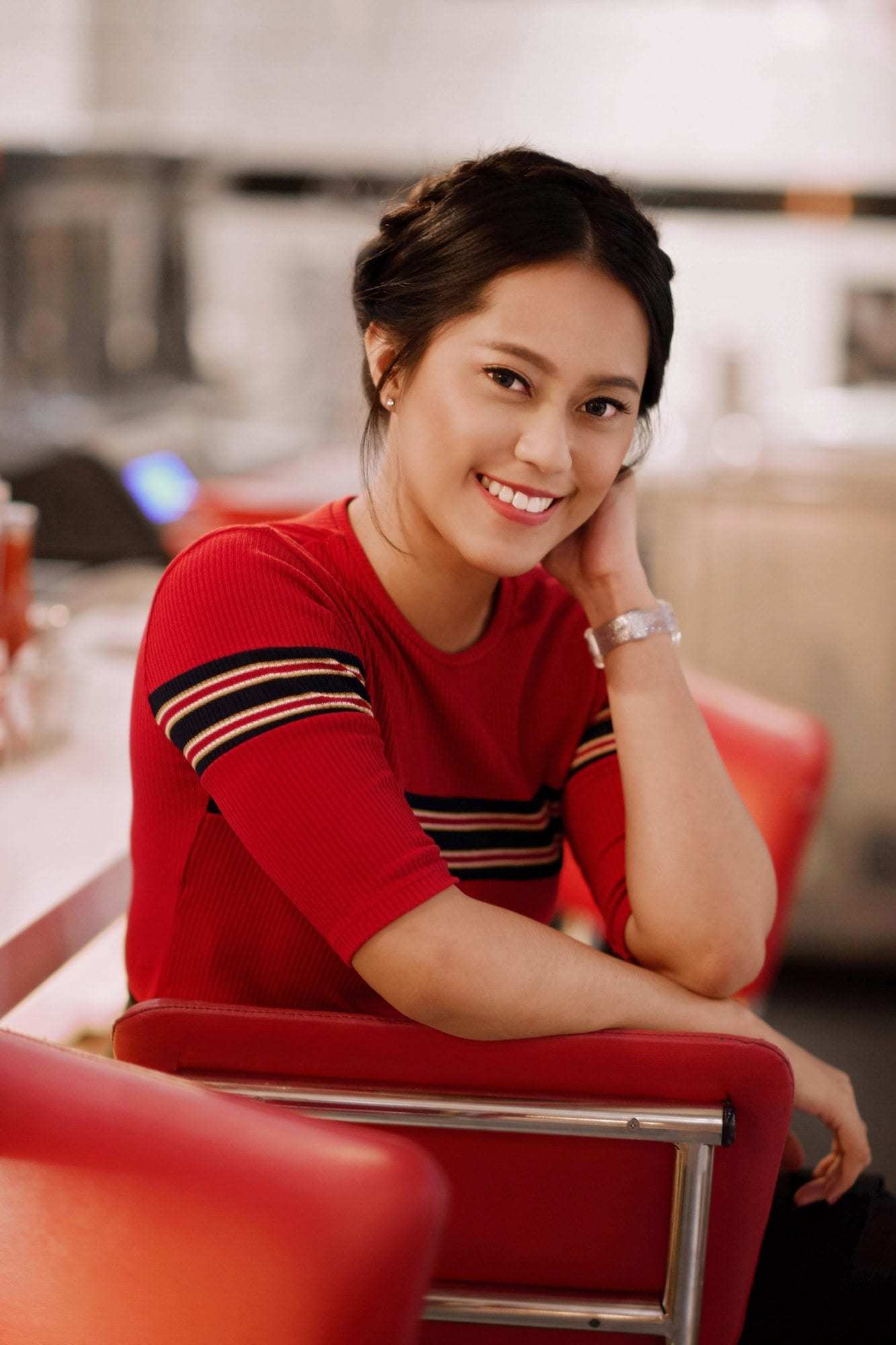 Coiffures asiatiques : Femme asiatique avec des cheveux bruns en tresse couronne portant un haut rouge.