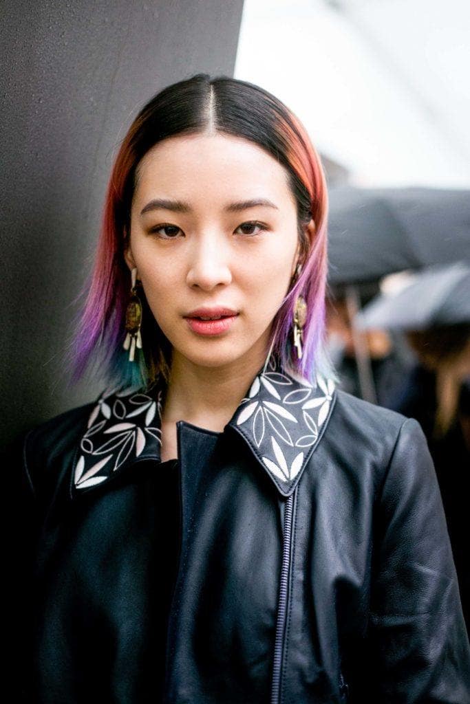 Coiffures asiatiques : Femme asiatique aux cheveux longs, raides et multicolores, portant une veste en cuir.
