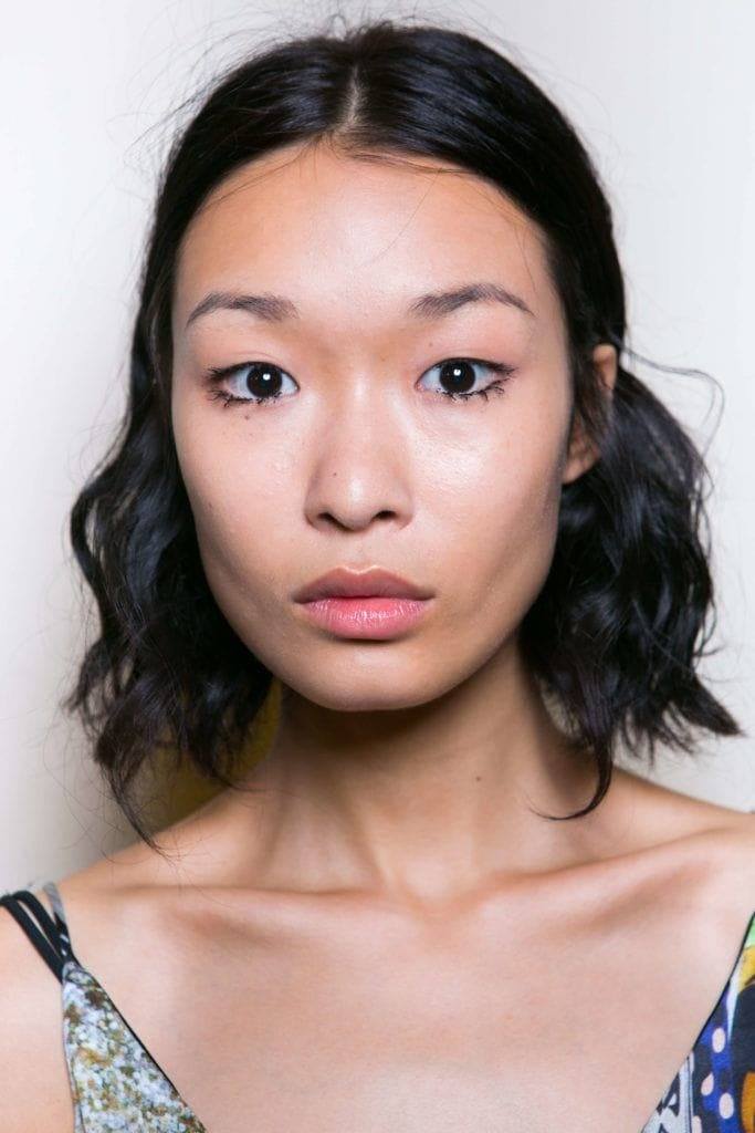 Coiffures asiatiques : Femme asiatique avec un carré long ondulé brun foncé.