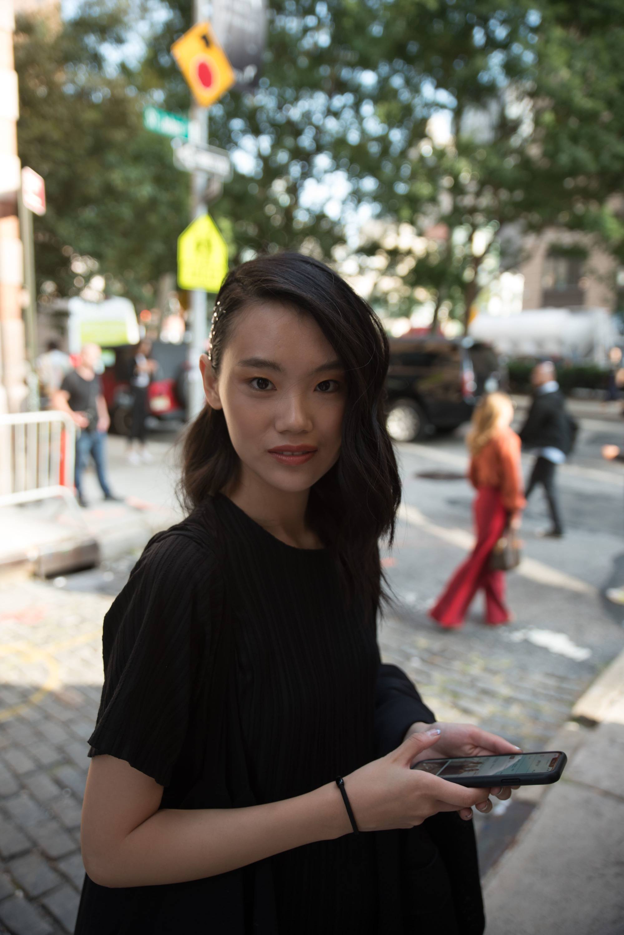 Femme avec des cheveux asiatiques foncés à longueur d'épaule coiffés sur le côté.
