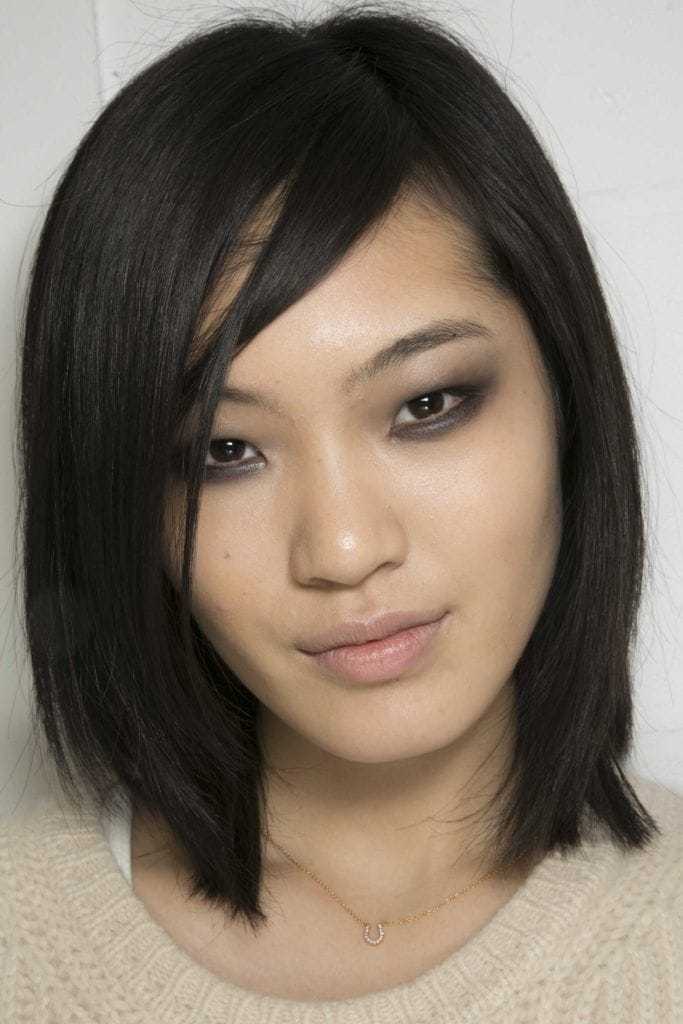Coiffures asiatiques : Femme asiatique avec cheveux bruns foncés, longs et raides.