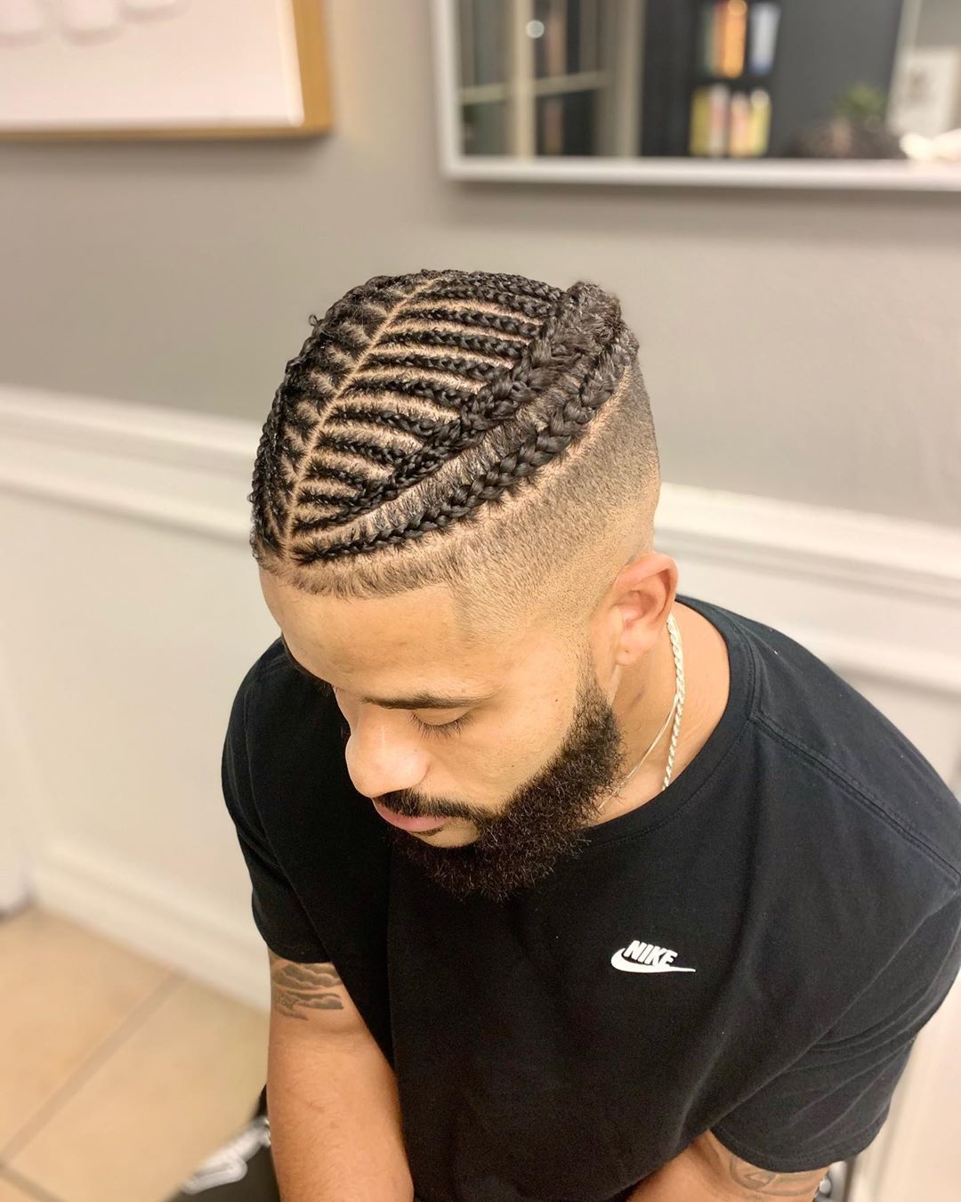 Homme avec des tresses et une sous-coupe.