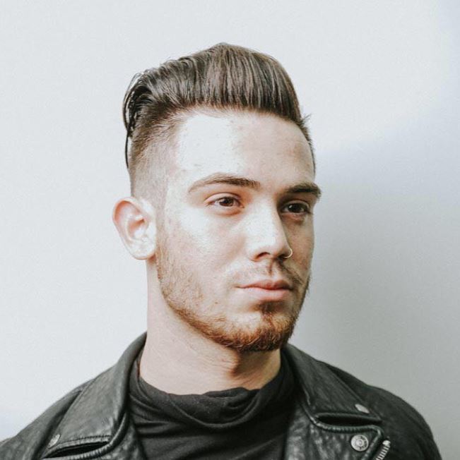 Vue de face d'un homme aux cheveux bruns avec une coupe courte en arrière.