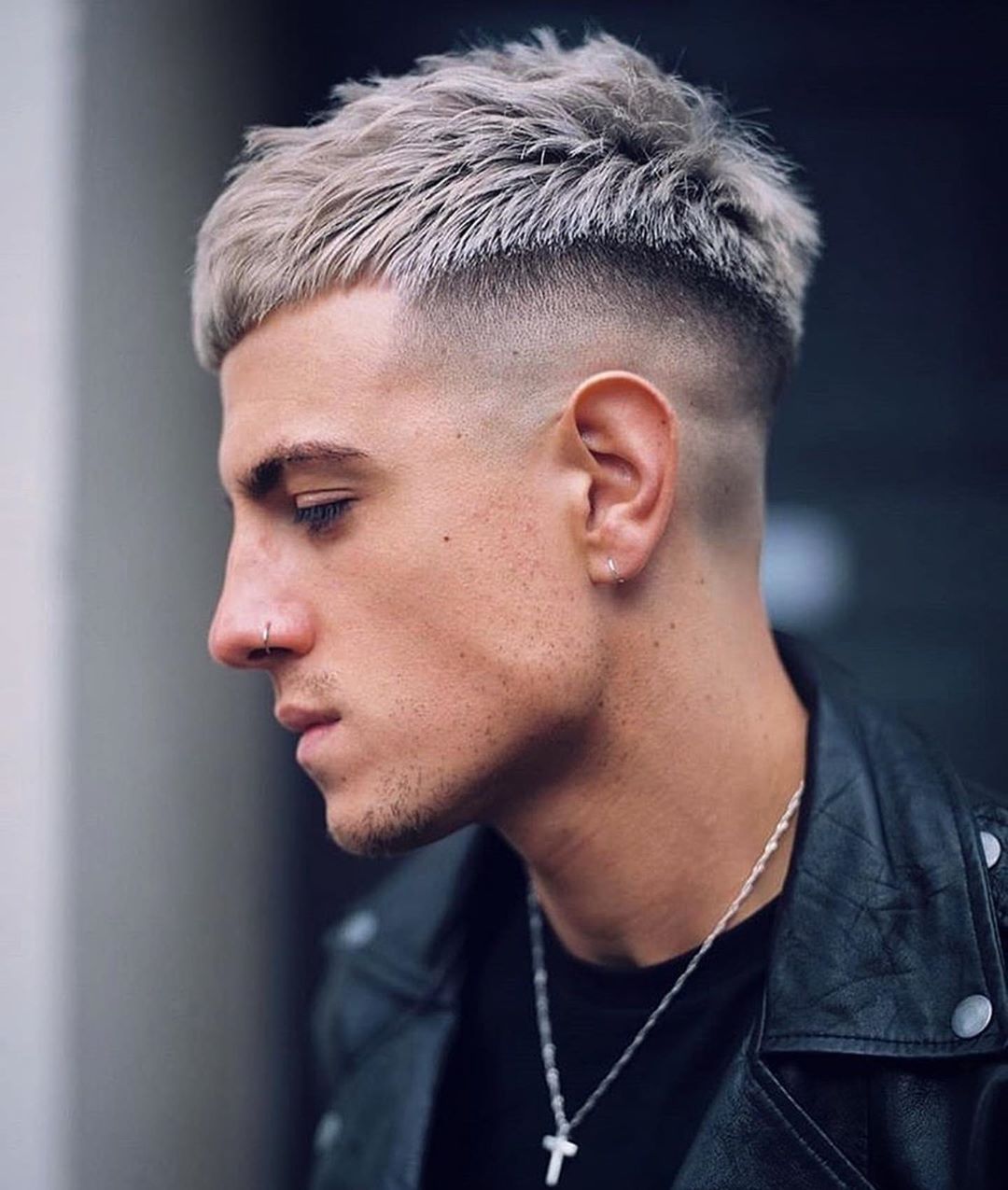 Homme avec une coupe de cheveux blonde cendrée et platine avec une sous-coupe.