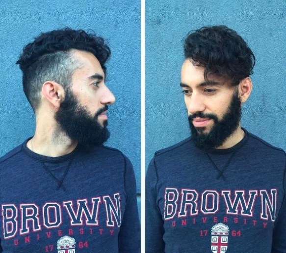 Vue de face d'un homme avec des cheveux noirs, une barbe et une coupe courte. 