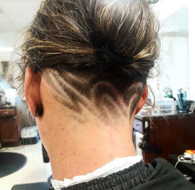 cheveux bruns avec un chignon et une coupe courte sur la nuque. 