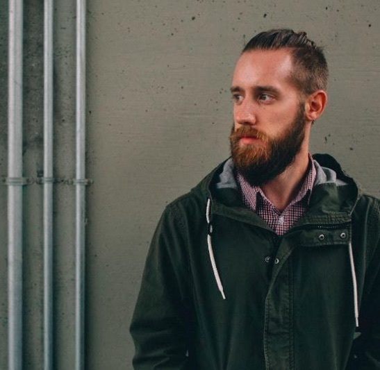 Vue de face d'un homme avec un chignon d'homme barbu et une sous-coupe. 