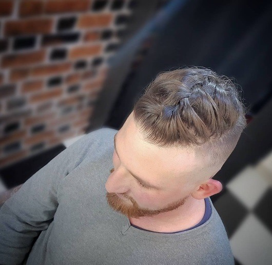 Vue d'oiseau d'un homme avec une coiffure tressée avec une coupe courte.
