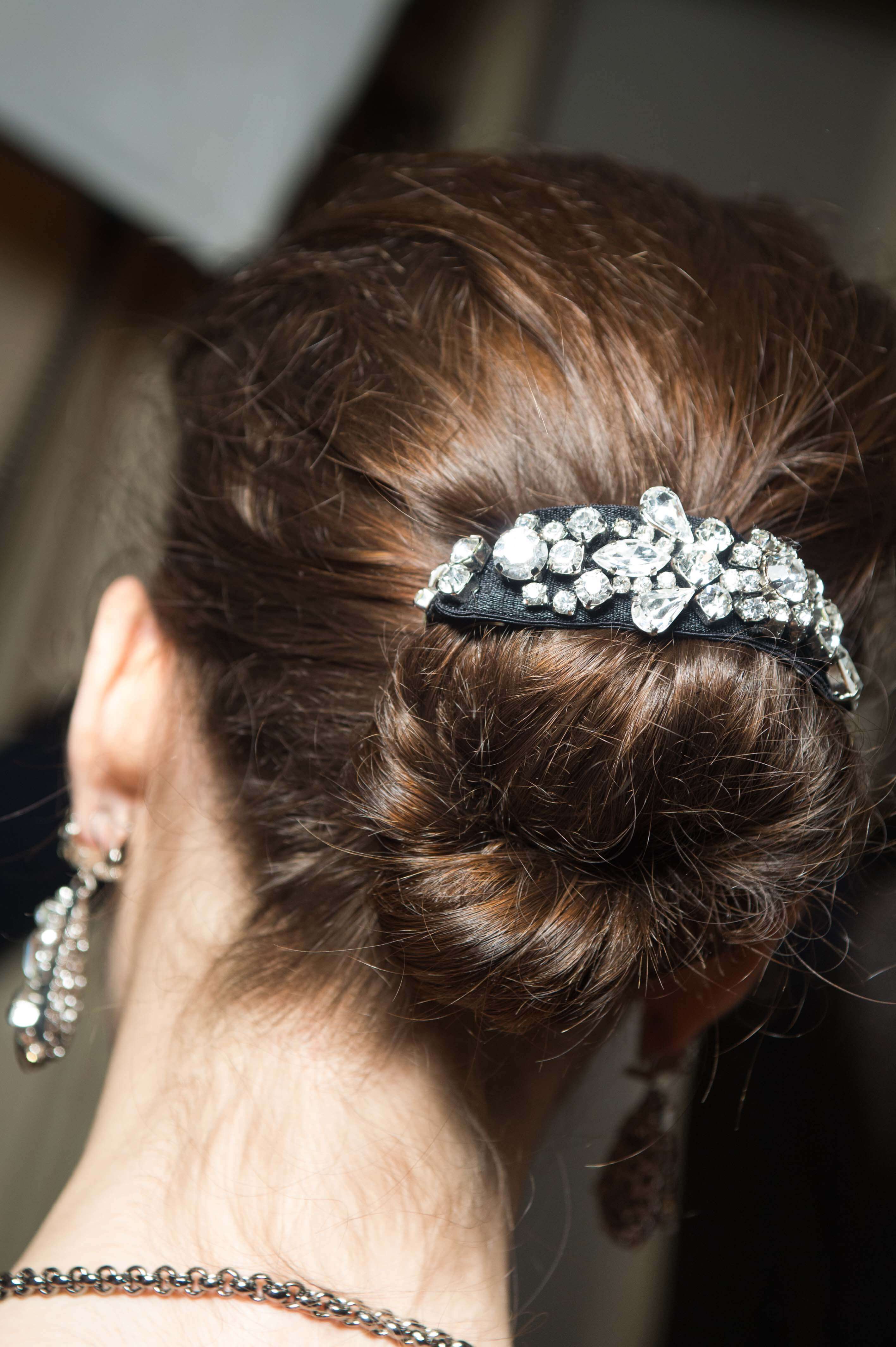 vue de dos d'une brune avec ses cheveux en chignon désordonné avec une manchette de chignon à bijoux