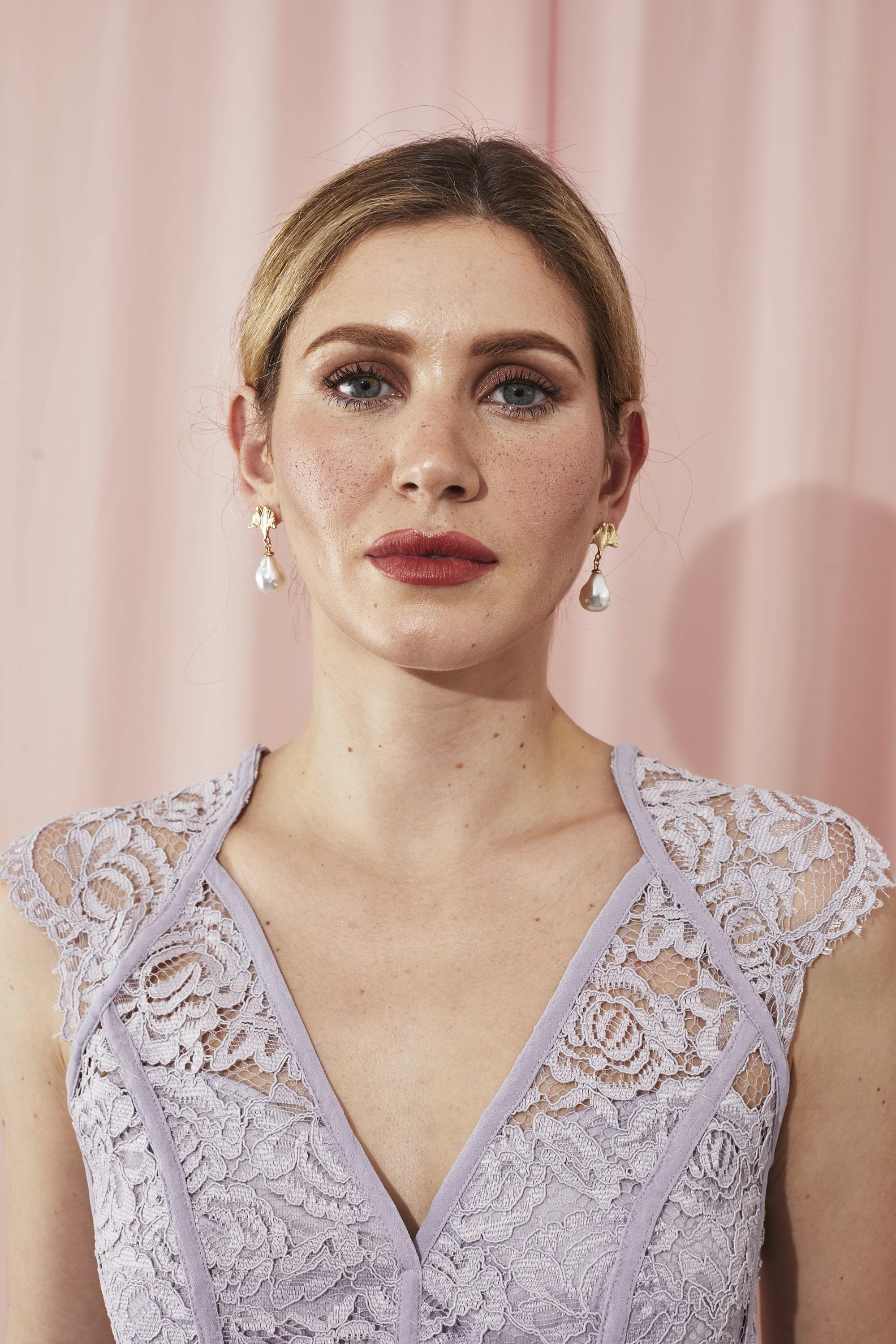 Femme avec des cheveux blonds coiffés en un updo lisse.