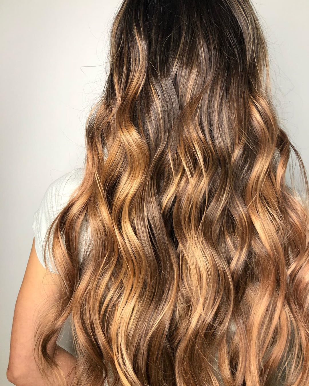 Femme avec de longs cheveux ondulés blond miel foncé