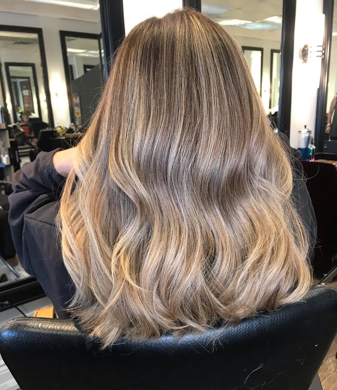 Femme avec des cheveux naturels blond miel ondulés mi-longs.