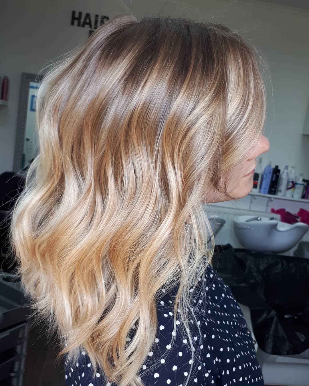 Femme avec des cheveux mi-longs ondulés de couleur beige miel.