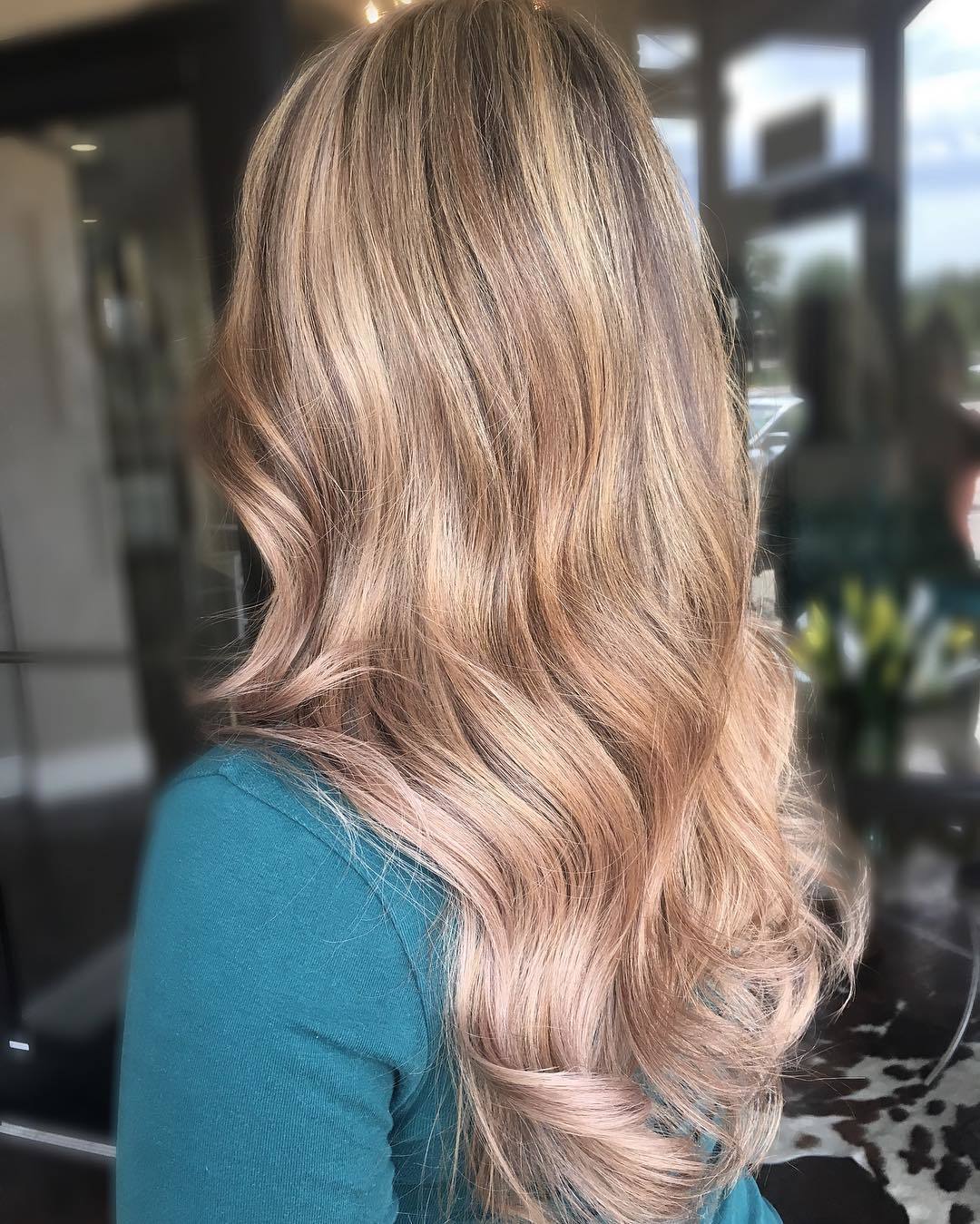 Femme avec de longs cheveux ondulés blond miel cendré.