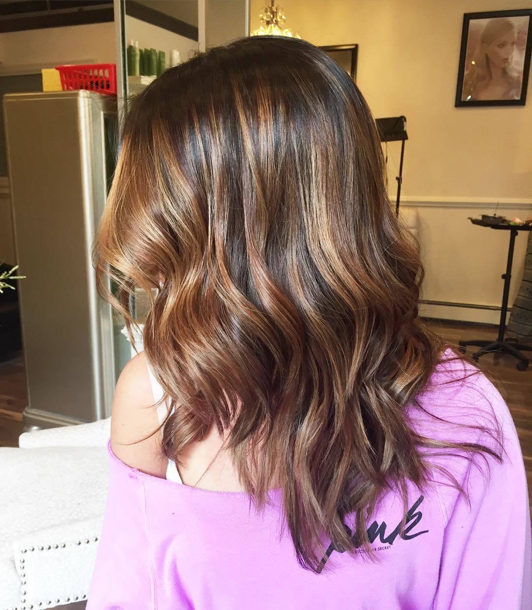 Femme avec des cheveux mi-longs ondulés de couleur châtain miel.