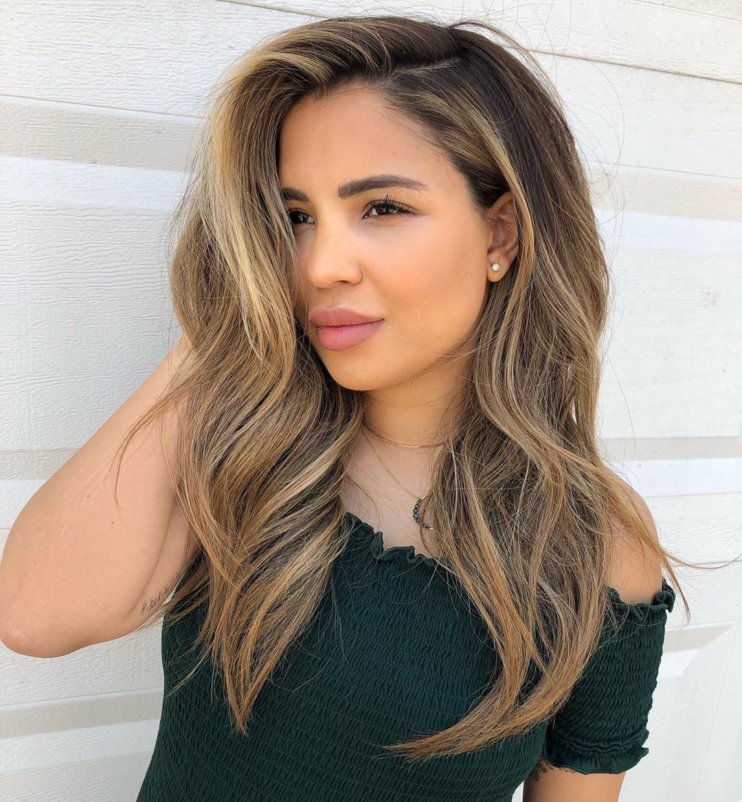 Femme avec des cheveux balayage ondulés blond miel chaud.