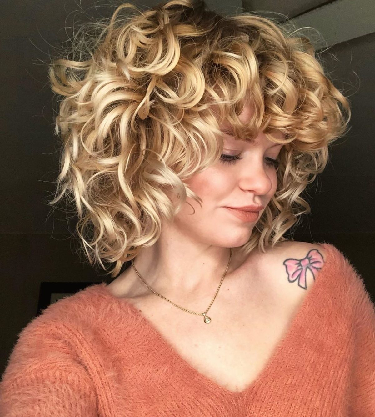 La coupe blonde bouclée avec frange
