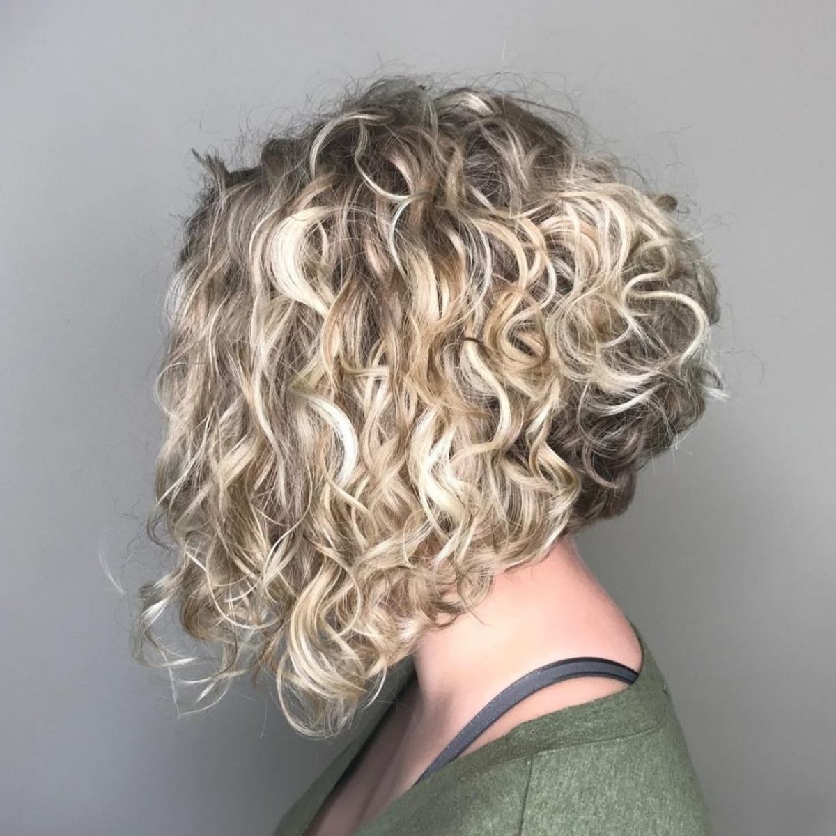 Coupe de cheveux bouclée à la ligne A avec mèches blondes