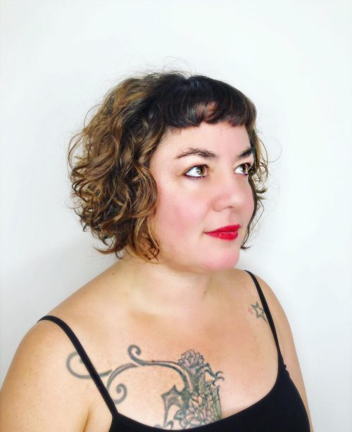 Cheveux courts bouclés avec frange pour un visage rond