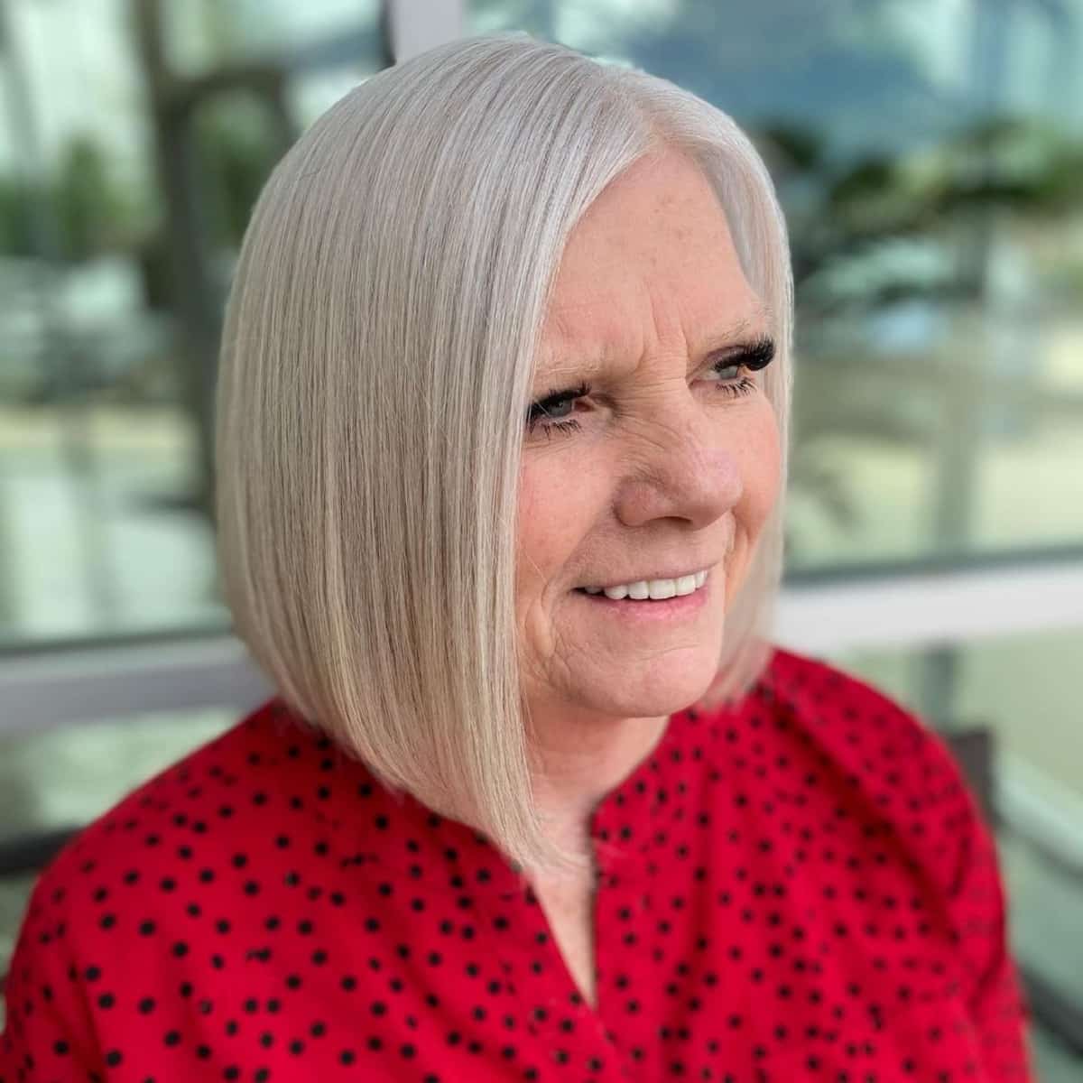 Lob asymétrique élégant pour les femmes de plus de 60 ans aux cheveux raides.