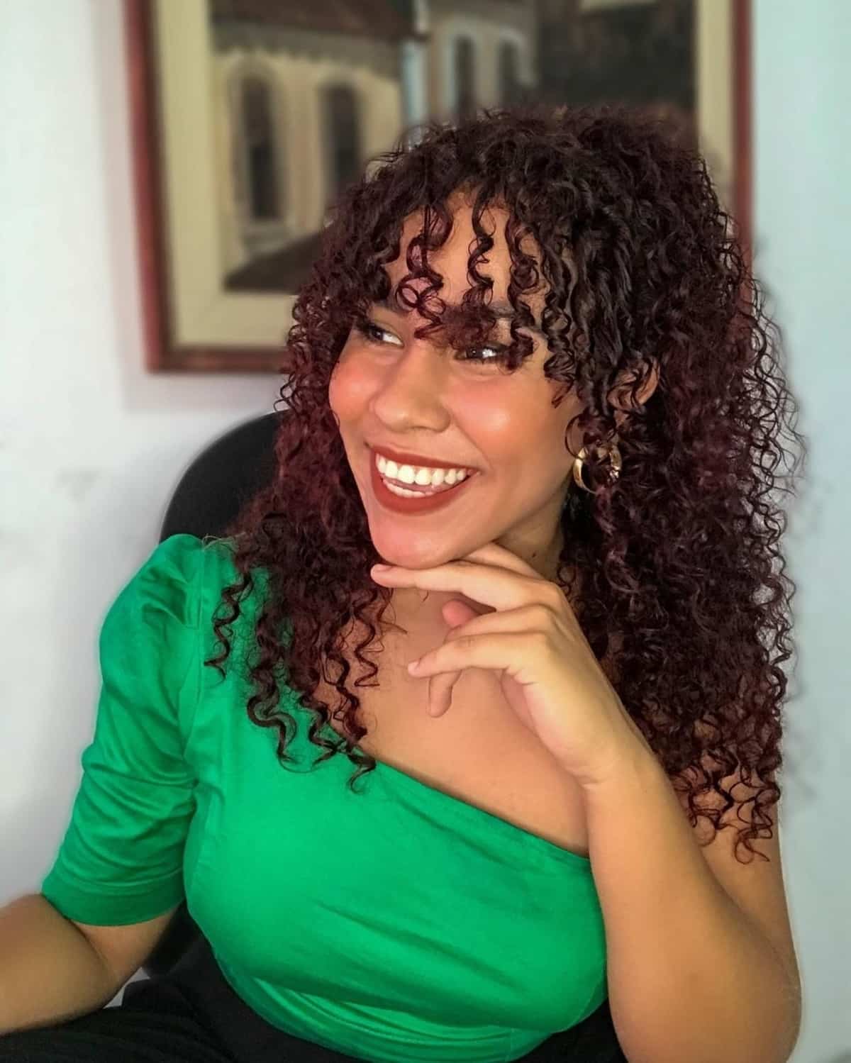 Cheveux bouclés à moitié relevés avec une frange