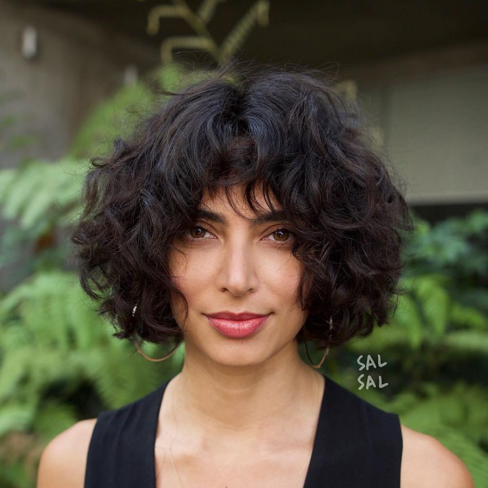 Cheveux courts et bouclés avec une frange pour atténuer les sourcils