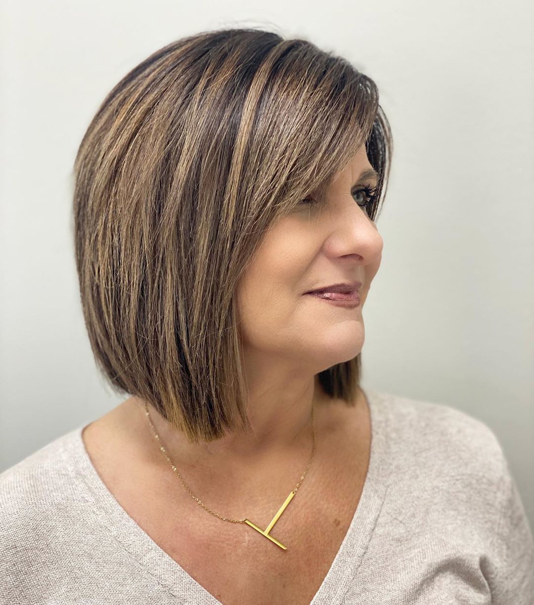 Lob avec frange balayée sur le côté pour les femmes aux cheveux épais de 50+.
