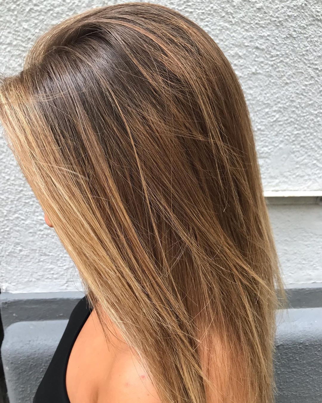 Cheveux bruns avec des mèches caramel et blond doré.