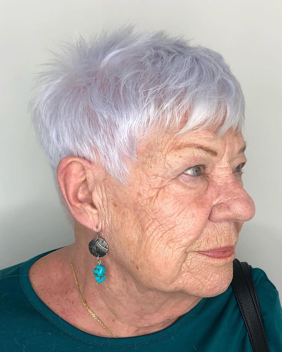 Femme de plus de 70 ans avec des cheveux gris courts et coupés.