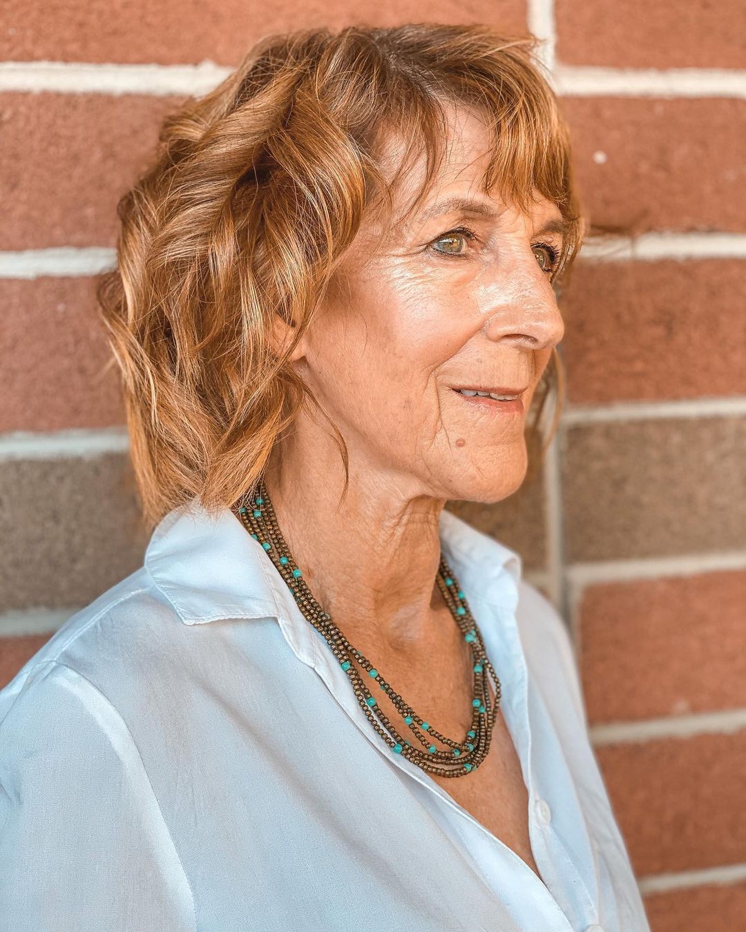 Femme de 70 ans avec une coupe de cheveux ondulée.