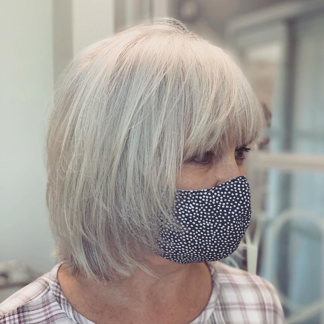 Coupe de cheveux grise dégradée pour les femmes de plus de 55 ans aux cheveux fins.