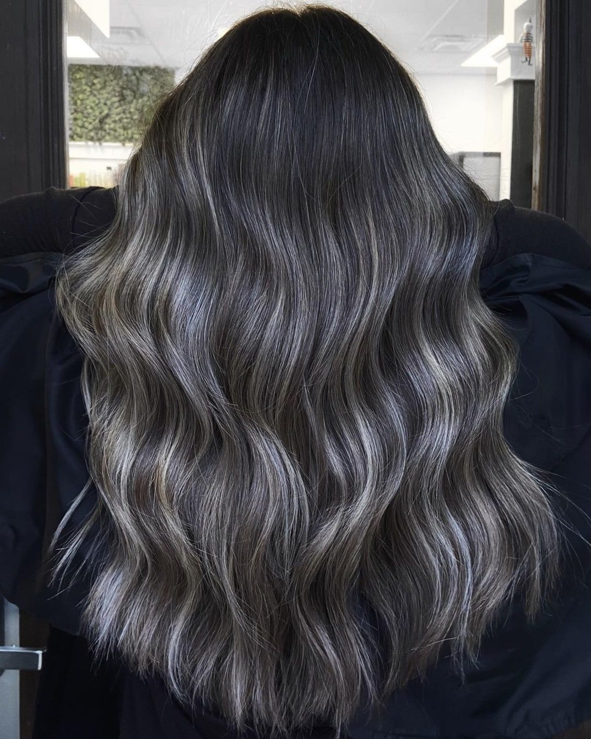 Mèches blondes cendrées sur des cheveux longs foncés