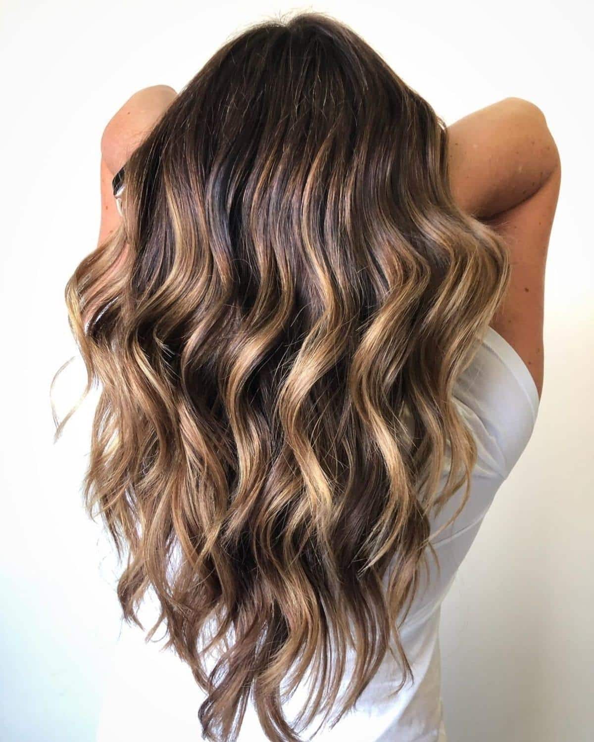 Cheveux bruns foncés avec des mèches ensoleillées.