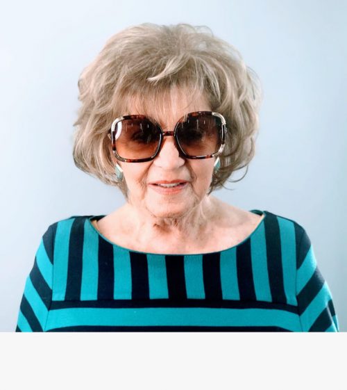 Coupe dégradée pour une personne de 60 ans avec des cheveux gris naturels.
