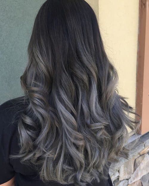 Des racines foncées aux cheveux ombrés gris fumé.