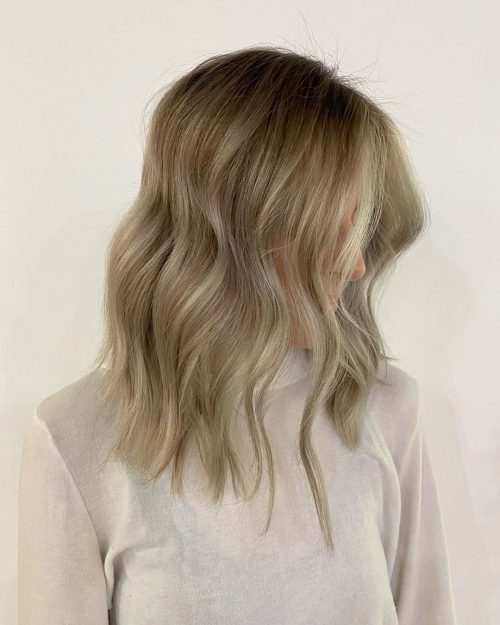 Couleur de cheveux marron clair avec des mèches balayage blondes encadrant le visage.