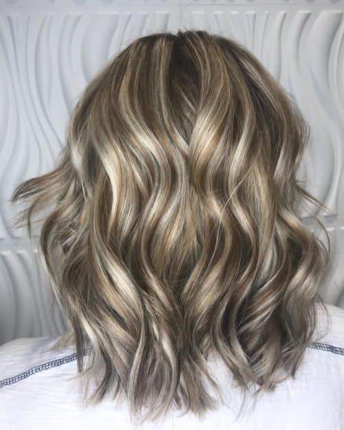 Mèches blondes brillantes sur cheveux bruns foncés