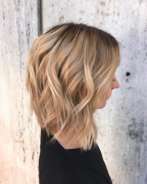Mèches caramel et blondes sur des cheveux bruns plus clairs avec des racines foncées.
