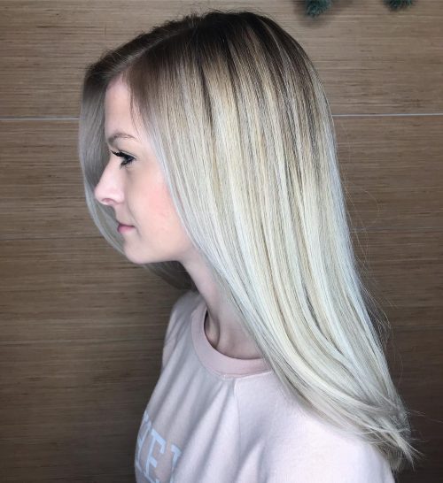 Cheveux blond platine avec des racines naturellement foncées