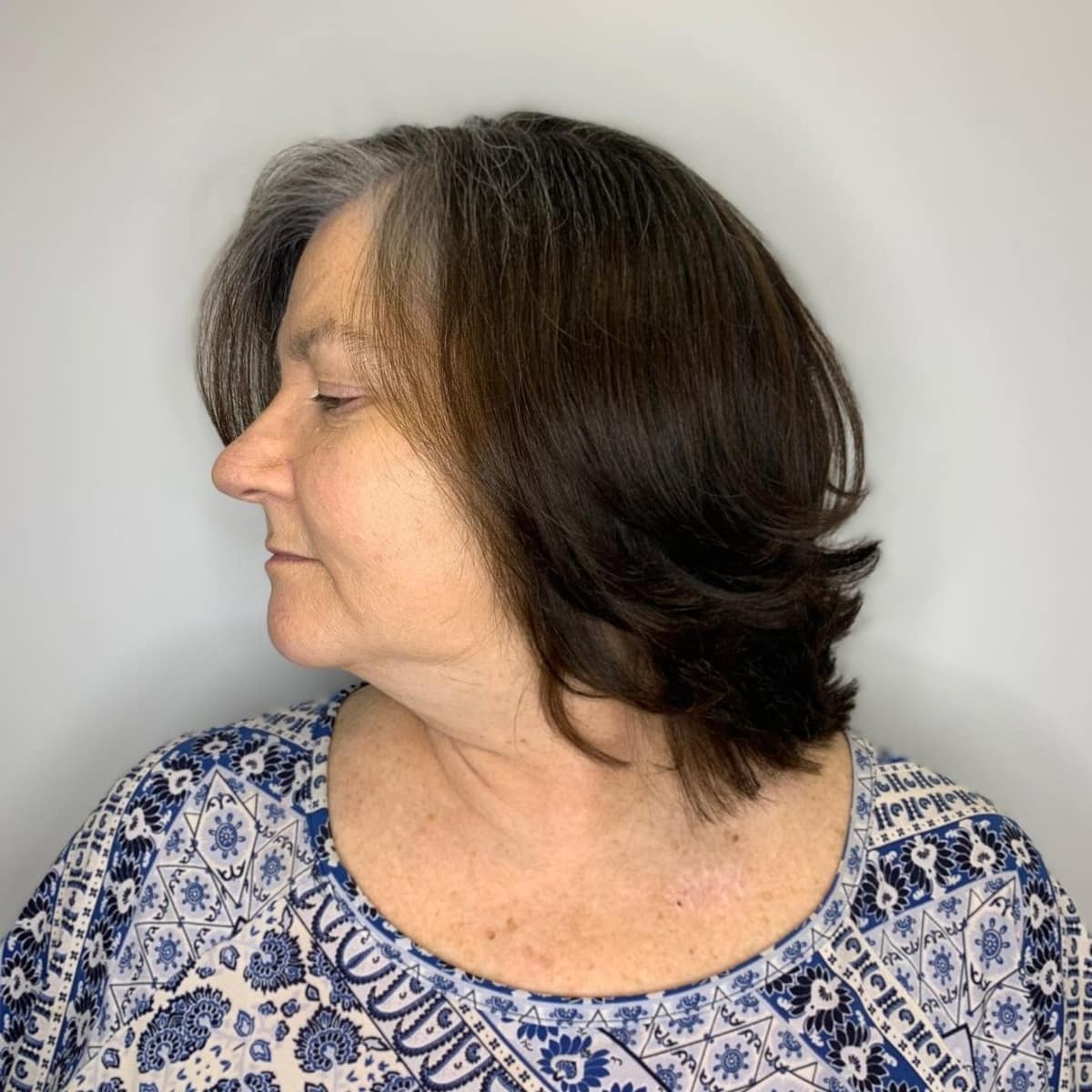 Coupe courte à moyenne pour une femme de plus de cinquante ans aux cheveux fins.