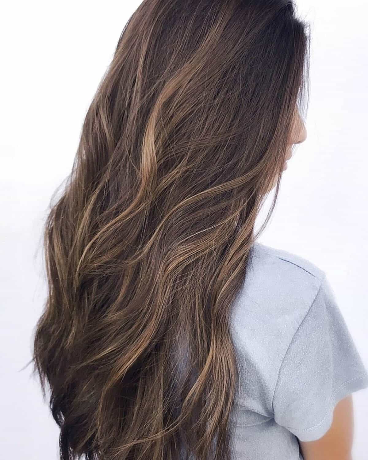 mèches sableuses brun miel sur cheveux bouclés
