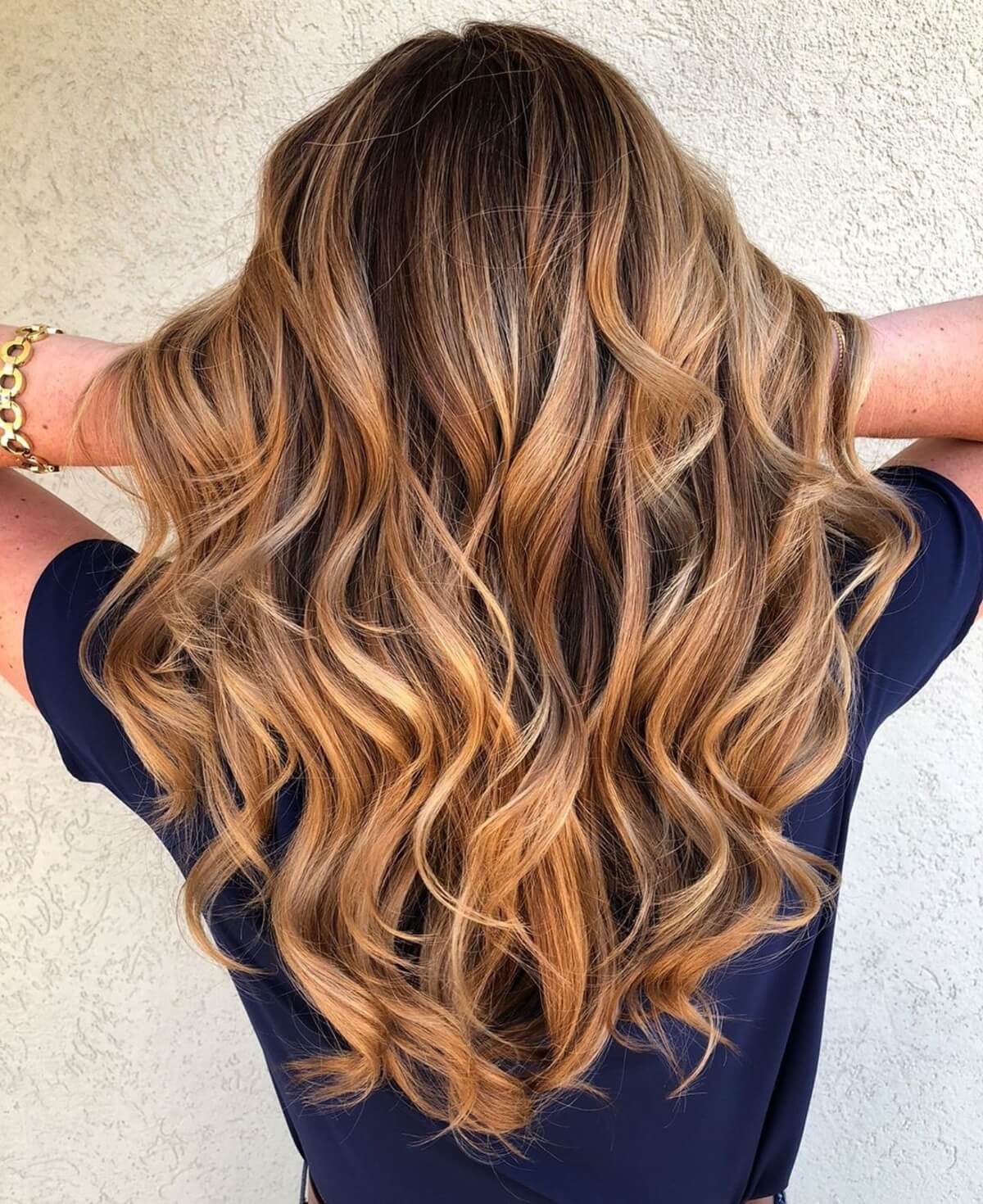 Cheveux bruns foncés avec des reflets auburn et caramel.