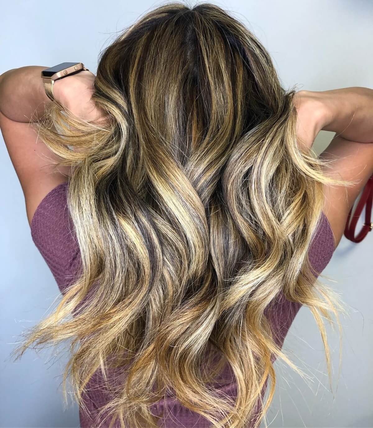 Cheveux bruns foncés avec des mèches caramélisées au miel.