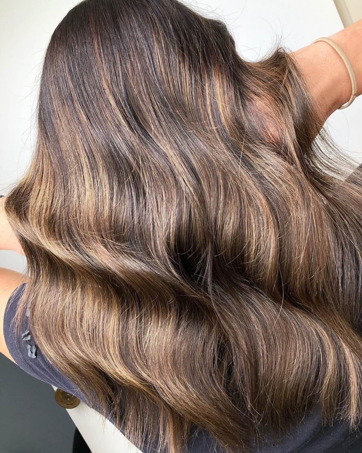 cheveux marron foncé avec des mèches caramel clair sur cheveux mi-longs