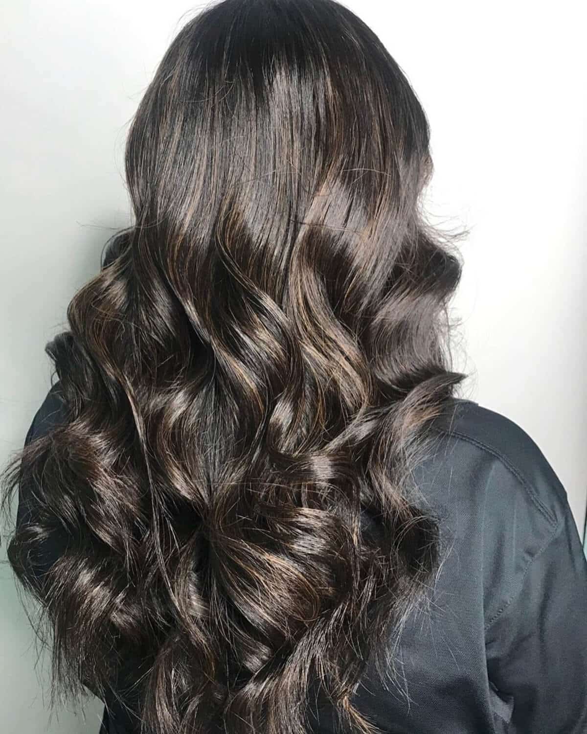 cheveux châtain foncé avec de subtils reflets caramel