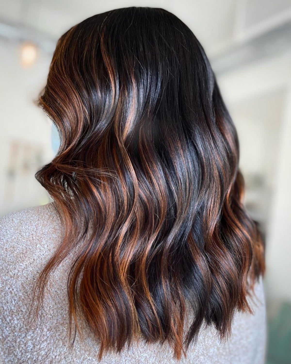 Mèches cuivrées sur une couleur de cheveux noire
