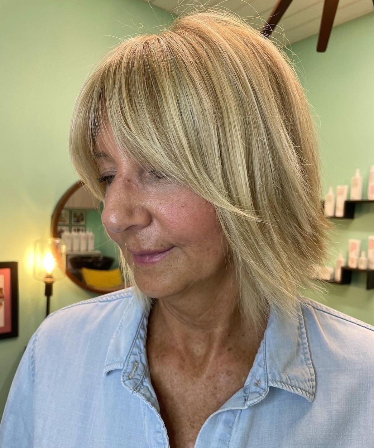 Coiffure droite avec frange en rideau pour les femmes plus âgées.