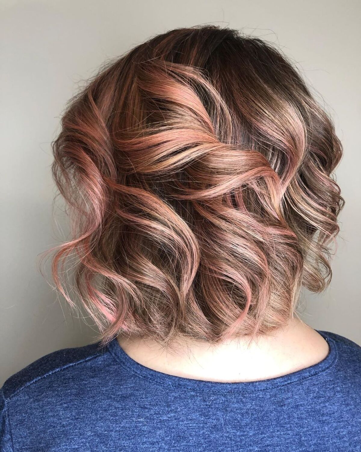 Une nuance d'or rose sur des cheveux bruns courts