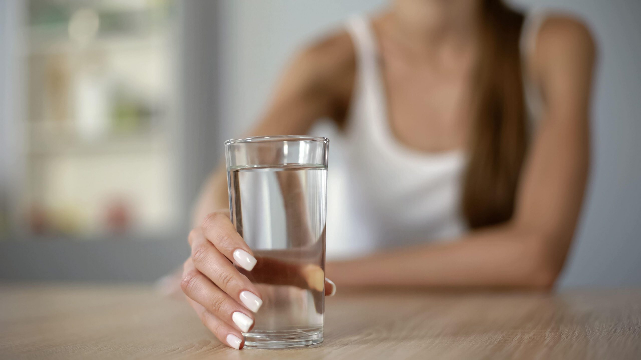 Une femme qui boit de l'eau pour réduire les effets de l'alcool 